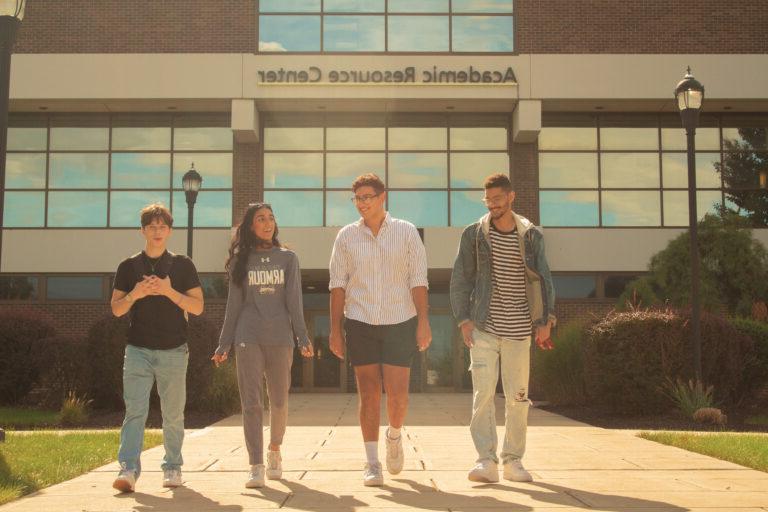 图为四名学生走在学术资源中心前.